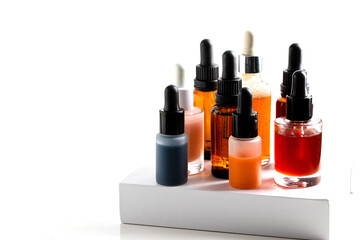 Different dropper bottles with serum, oil and cream on the podium. Modern cosmetic and skin care cocnept.