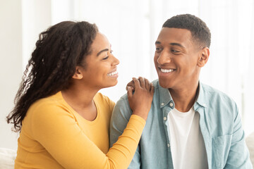 Lifestyle, romantic and date at home. Smiling pretty millennial african american wife looking at husband