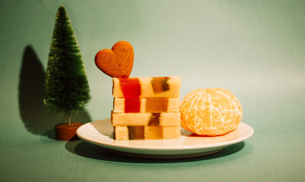 Marzipan marmalade turrone on orange background. Spanish dessert made from almonds, honey, sugar, eggs. Christmas sweets, heart-shaped cookie. New Year pine tree decor 2023. Heart cookies treats sweet
