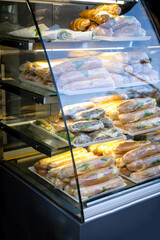 Delicious sandwiches for sale at Greek market - wrapped in plastic film - stored in cold refrigerator