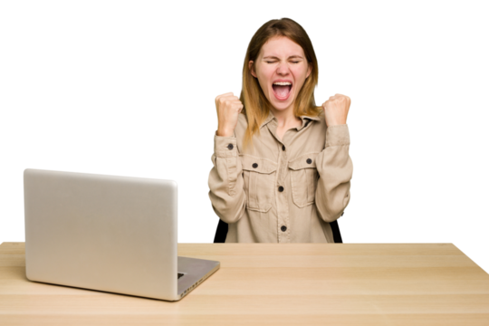 Young caucasian woman in a workplace working with a laptop isolated cheering carefree and excited. Victory concept.
