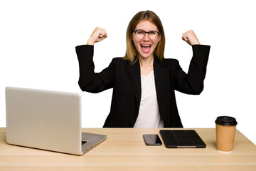 Young business caucasian woman working on her workplace cutout isolated showing strength gesture with arms, symbol of feminine power