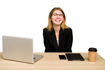 Young business caucasian woman working on her workplace cutout isolated laughing and having fun.