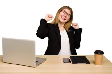 Young business caucasian woman working on her workplace cutout isolated celebrating a special day, jumps and raise arms with energy.