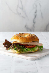 bagel with ham and vegetables on a white background