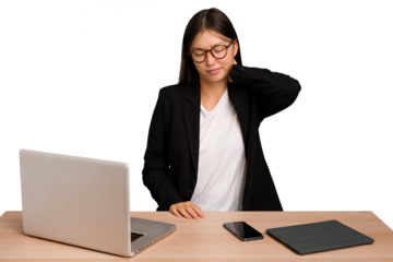 Young business asian woman sitting on a table isolated having a neck pain due to stress, massaging and touching it with hand.