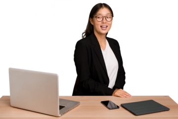Young business asian woman sitting on a table isolated looks aside smiling, cheerful and pleasant.