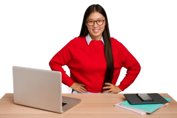 Young student asian woman in a workplace with a laptop isolated confident keeping hands on hips.