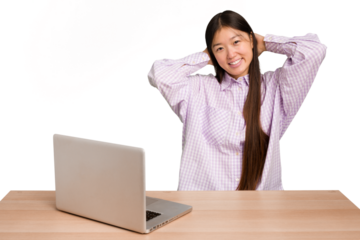Young student asian woman in a workplace with a laptop isolated stretching arms, relaxed position.
