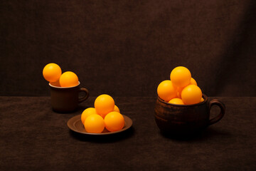 Still life with brown cups and orange balls