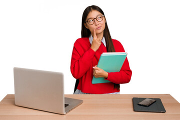 Obraz premium Young student asian woman in a workplace with a laptop isolated