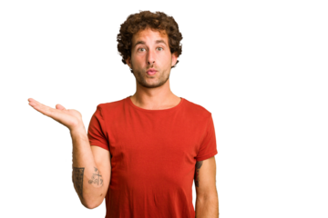 Young curly smart caucasian man cut out isolated impressed holding copy space on palm.