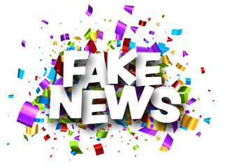 Fake news sign over colorful cut ribbon confetti background.