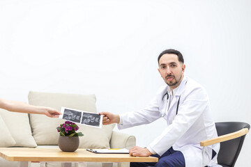 Naklejka premium Photo of doctor wearing lab coat giving an ultrasound result to his patient.