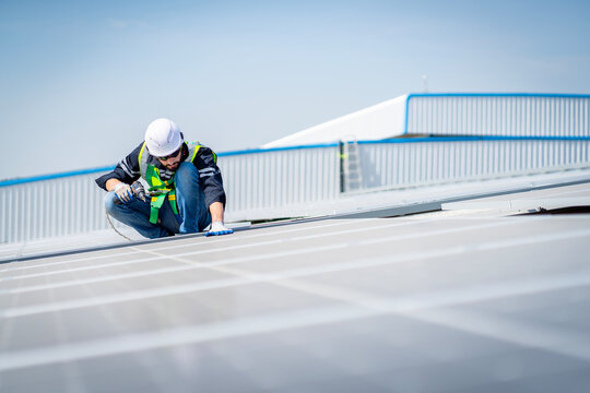 Male Engineer Installing Or Checking The Working Condition Of Solar Panels On The Roof Or At The Height Of The Factory For Saving Electricity Was Broken To Use Renewable Energy From The Sun