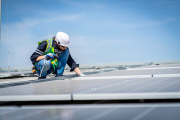 Male engineer installing or checking the working condition of solar panels on the roof or at the height of the factory for saving electricity was broken to use renewable energy from the sun