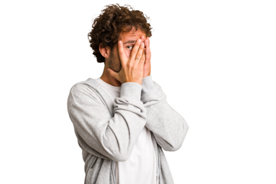 Young curly smart caucasian man cut out isolated blink through fingers frightened and nervous. - Powered by Adobe