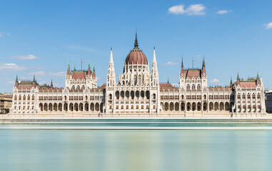 Hungarian parliament building on Danube, Budapest, long exposure square, clear blue sky, European architecture