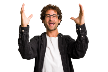 Young curly smart caucasian man cut out isolated celebrating a victory or success, he is surprised and shocked.
