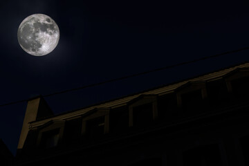 Full moon above the rooftop of French apartment building at night - low angle view cinematic photo - Powered by Adobe