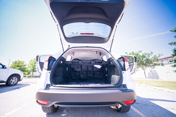 Empty car trunk open view with backseat car organizer with storage pockets. Modern hatchback SUV vehicle open cargo area. The automobile boot is open for luggage. Preparation for travel concept. - obrazy, fototapety, plakaty