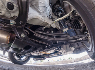 View of car suspension system and various chassis components. Mechanical Services. Brakes Inspection and tire inspection. Mechanical repair, safety inspection, used vehicle appraisal. - obrazy, fototapety, plakaty