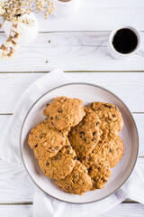 Oatmeal cookies with raisins on a plate on the table. Homemade pastries. Top and vertical view