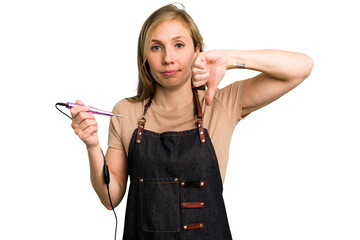 Young caucasian manicurist woman holding an electric file drill isolated showing a dislike gesture, thumbs down. Disagreement concept.