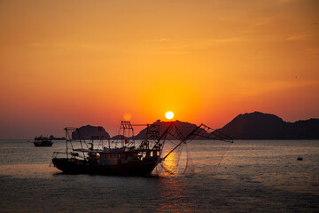 Fototapeta na wymiar Bateau de pêche dans la mer au Vietnam au coucher du soleil