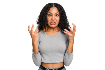 Young african american woman with curly hair cut out isolated upset screaming with tense hands.