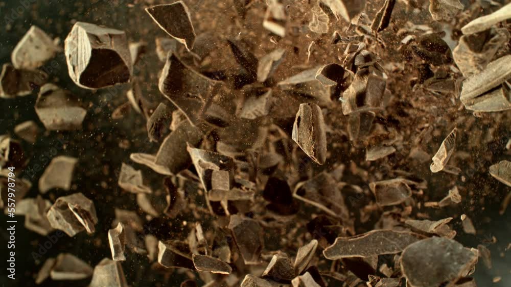 Poster super slow motion of rotating group of raw chocolate pieces. super fast camera motion. filmed on hig