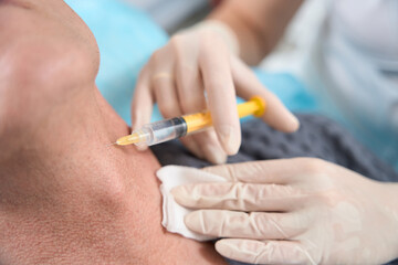 Doctor injecting platelet rich plasma into skin of human neck