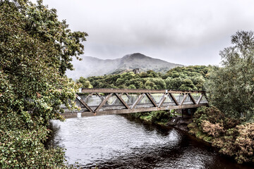 Railway bridge through the river with mountains on background