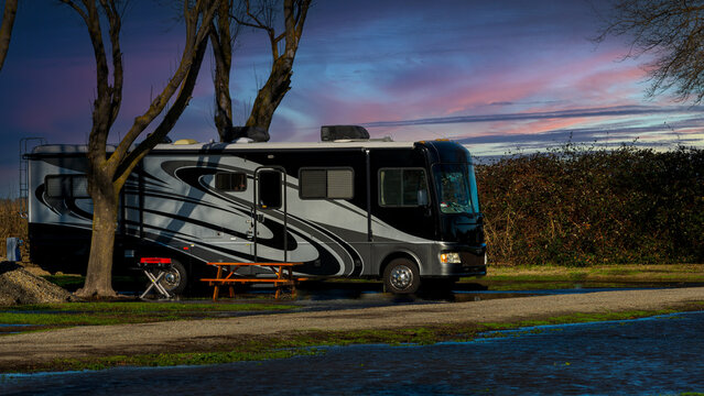 Rv motorhome parked lakeside under cloudy beautiful sky