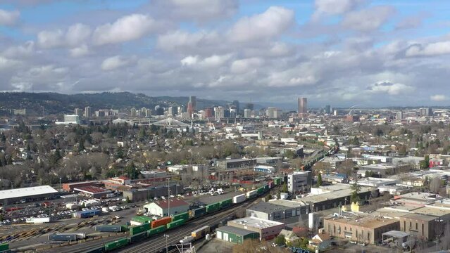 Cargo container train passing through Portland Oregon and the city center skyline seen in the distance.