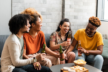 Brazilian friends drink and chat happily in their living room