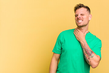 Young caucasian handsome man isolated on yellow background touching back of head, thinking and...