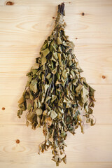 Birch broom hanging on a wooden wall