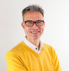 portrait of a man with glasses in business shirt and yeloow knitted pullover
