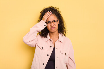 Young Brazilian curly hair cute woman isolated on yellow background tired and very sleepy keeping hand on head.