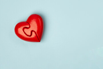 Fototapeta premium Red heart of two folded halves on a blue background with copy space . Psychology and Valentine day concept .
