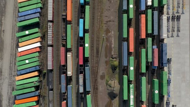 Aerial top down view of shipping containers on train cars at a railroad yard.