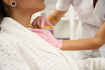 Medical worker doing neck plasmolifting for young lady