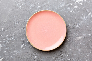 Top view of empty pink plate on cement background. Empty space for your design