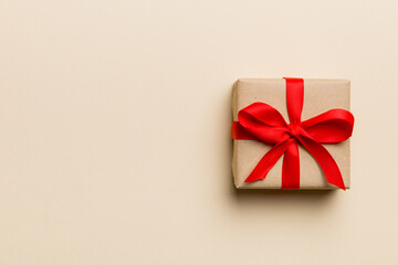 Valentine day composition: red gift box with bow and heart. Christmas present. View from above. Space for text. Holday greeting card