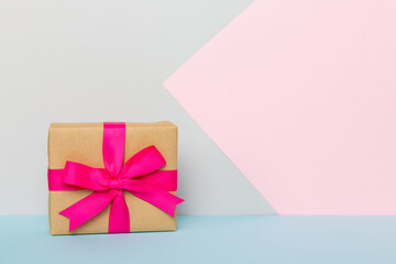 holiday paper present tied pink ribbon bow top view with copy space. Flat lay holiday background. Birthday or christmas present. Christmas gift box concept with copy space