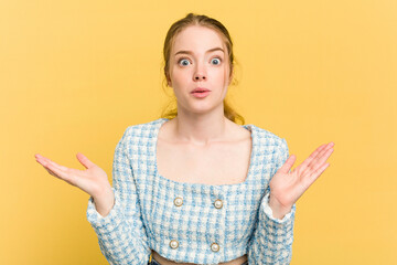 Young caucasian redhead woman isolated on yellow background surprised and shocked.
