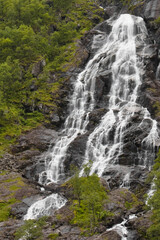 A beautiful waterfall in the forest with several smaller streams flowing over the rocks.