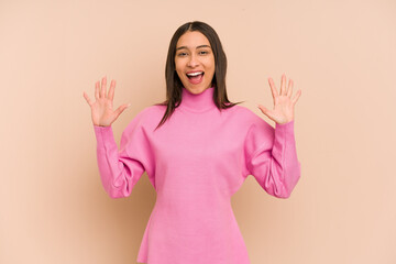 Young colombian woman isolated on beige background receiving a pleasant surprise, excited and...