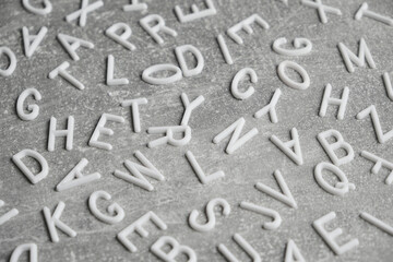 White letters English alphabet gray concrete background.